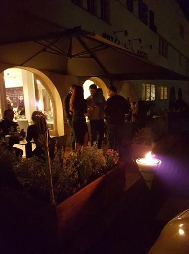 a group of people standing under an umbrella at night at Hôtel de la Poste Piscine in Peymeinade