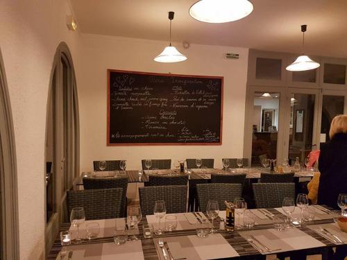 a dining room with a long table with wine glasses at Hôtel de la Poste Piscine in Peymeinade