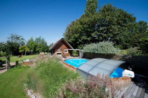 a small swimming pool next to a house at Harlingen Garden Apartment in Midlum