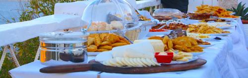 ein Tisch mit Tellern voller Essen auf einem Tisch in der Unterkunft Tholaria Boutique Hotel in Astypalea-Stadt