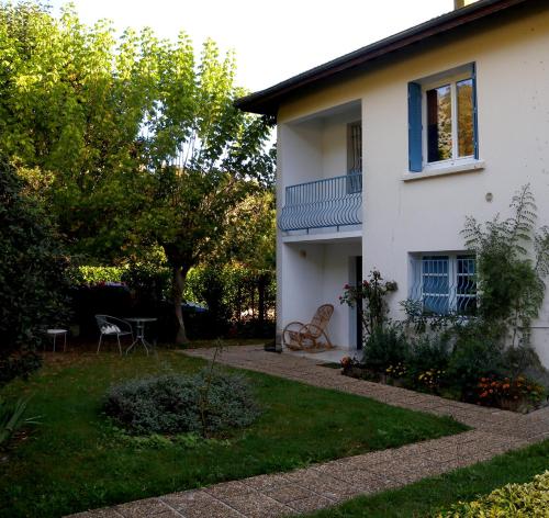 ein weißes Haus mit einem Balkon und einem Hof in der Unterkunft Gîte "Au Gré de l'Adour" in Aire-sur-lʼAdour