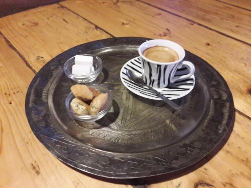 a black plate with a cup of coffee and cookies at Camping Auberge Zebra in Ouzoud
