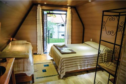 a bedroom with two beds in a room with a window at Pousada Valle das Colinas in Tiradentes