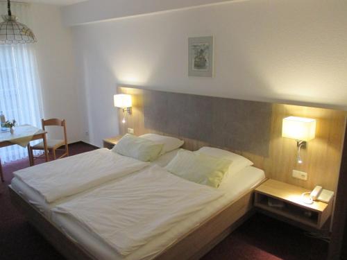 ein Schlafzimmer mit einem großen weißen Bett mit zwei Lampen in der Unterkunft Hotel Reuterhof in Reuterstadt Stavenhagen