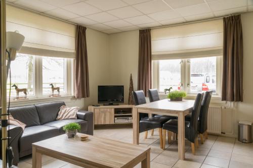a living room with a couch and a table at Recreatieoord Hippique in Westendorp
