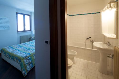a bathroom with a bed and a sink and a toilet at Old Harbour House in Grado