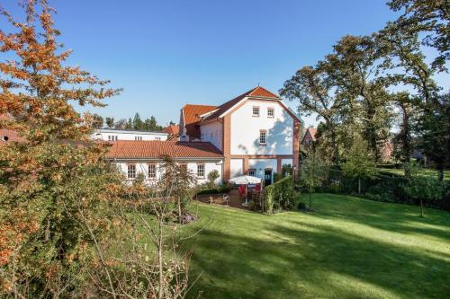 une grande maison avec une grande cour avec une pelouse dans l'établissement alte Molkerei, à Lindern