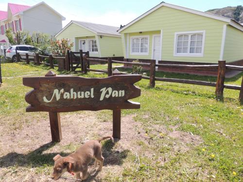 a dog standing next to a wooden park sign at Complejo "Nahuel Pan " in El Chalten