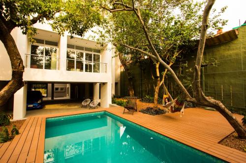 a house with a swimming pool and a wooden deck at Tapu'a Departamentos in Asuncion