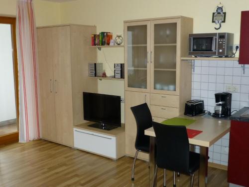 a kitchen with a table with chairs and a television at Abendsonne in Bamberg