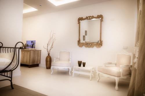 een witte kamer met 2 stoelen en een spiegel bij Le Jardin Potager in Rome
