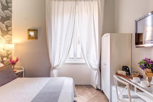 a bedroom with a white bed and white curtains at La Casa Di Amy in Rome