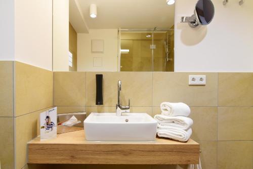 a bathroom with a sink and towels on a counter at Hotel Alte Vogtei in Wolframs-Eschenbach