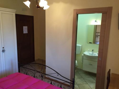 a bedroom with a bed and a sink and a mirror at Affittacamere Il Colle in Faicchio