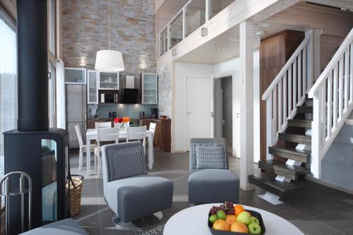 a kitchen and living room with a staircase and a table with fruit at Holiday Club Himos Apartments in Jämsä