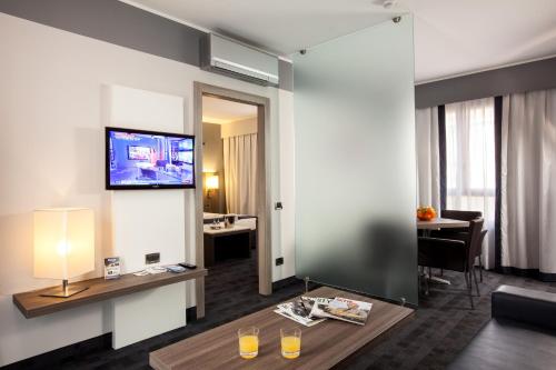 a living room with a tv on a wall at Best Western Plus Borgolecco Hotel in Arcore