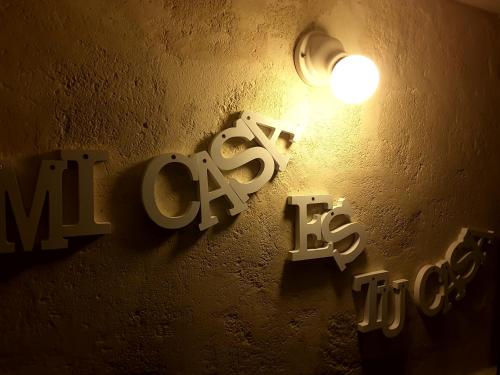 Un cartello su un muro con una luce sopra. di Sassi SediciDiciotto a Matera