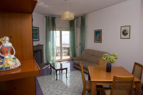 uma sala de estar com uma mesa e um sofá em Bouganville & Sea em Amalfi