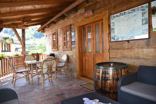 a wooden porch with a table and chairs and a barrel at Holiday Homes 4N in Gornje Jesenje