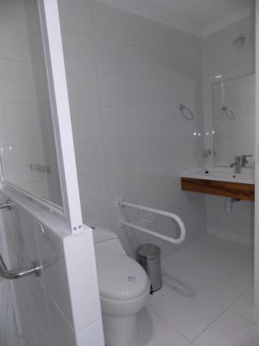 a white bathroom with a toilet and a sink at Cabañas Inadeqin in Ensenada