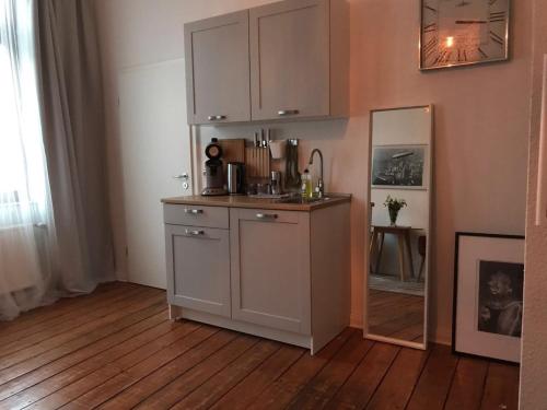 Una cocina con un fregadero y un espejo en una habitación. en Bremer Viertel, en Bremen
