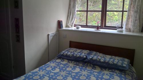 a bedroom with a bed with a pillow and a window at Rhymney House hotel in Caerphilly