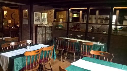 a restaurant with tables and chairs in a room at Rhymney House hotel in Caerphilly