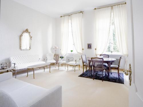 un soggiorno con mobili bianchi e tavolo di Royal Apartment City Center Baden-Baden a Baden-Baden