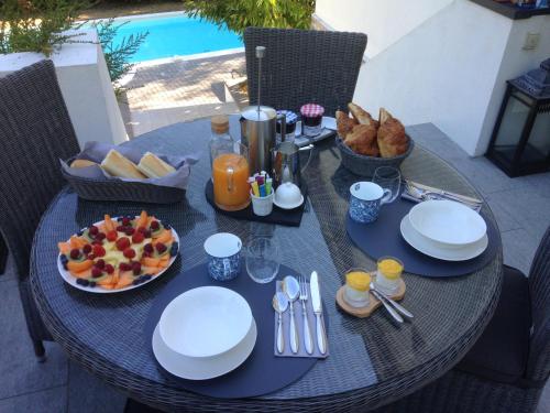 einen Tisch mit Teller mit Lebensmitteln und Obst darauf in der Unterkunft Les Hortensias in Lantosque