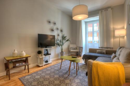 a living room with a couch and a tv at Angel's Duplex Terrace Five Bedrooms in Lisbon