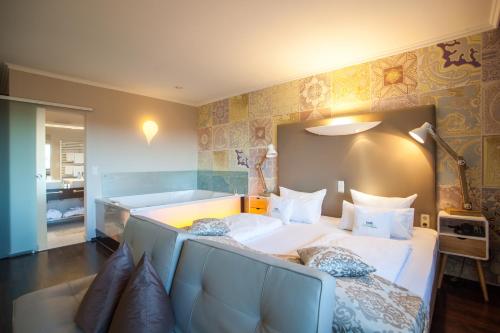 a bedroom with a large bed and a couch at Retro Design Hotel in Langeoog