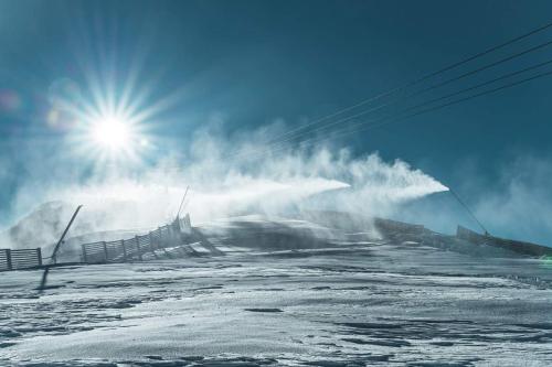 a snow covered slope with the sun in the sky at Apartman Chopok Juh Ema Superior in Tale