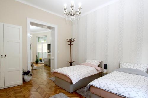 City Center Apartment MIKA في بلغراد: غرفة نوم بسريرين وثريا