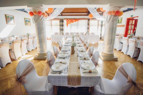 a long table in a room with white chairs at Juniperus Park Hotel Kecskemét in Kecskemét