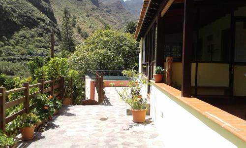 un balcón de una casa con macetas. en Casa Rural Rincón del Olivo, en Lomito Fragoso y Honduras