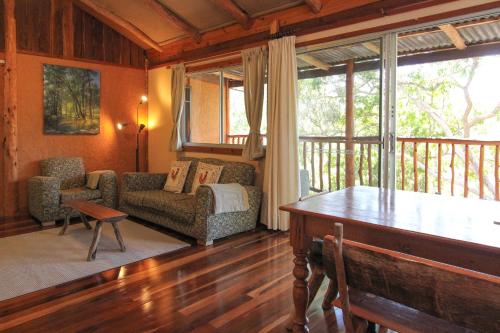 ein Wohnzimmer mit einem Sofa und einem Tisch in der Unterkunft Shady Creek Eco Cabin, Mudgee, Peaceful Country Getaway in Grattai