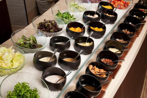 a buffet with many bowls of food on a table at Novotel Ambassador Suwon in Suwon