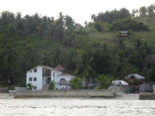a white house on the shore of the water at House Rapunzel in Oslob