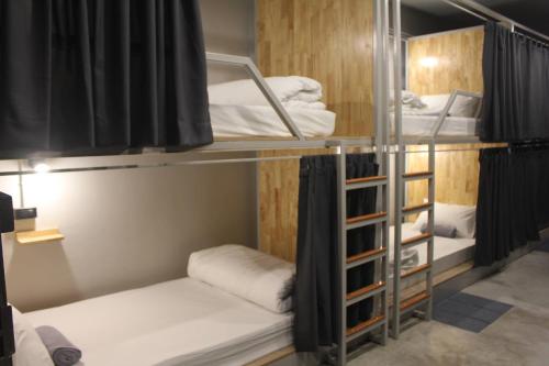 a room with three bunk beds in a room at Ekanek Hostel in Bangkok