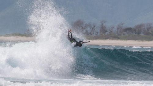 a man riding a wave on a board in the ocean at The Tree House Sumbawa in Huu