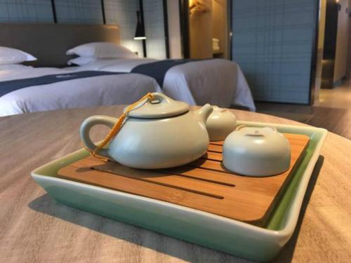 two tea pots on a tray on a table in a hotel room at 宜尚酒店厦门机场SM城市广场店 x 享机场接送 in Xiamen