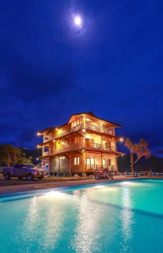 a building with a pool in front of it at night at The Tree House Sumbawa in Huu
