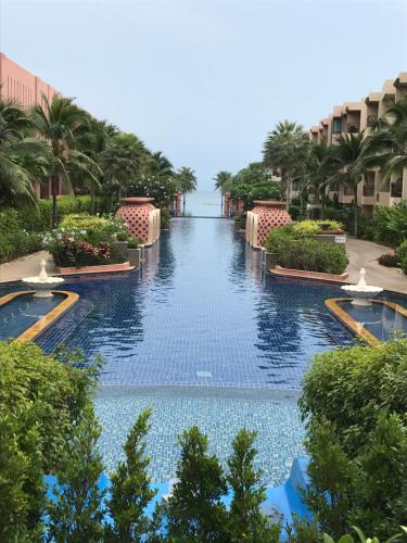 a swimming pool at a resort with palm trees at Marrakesh Residence 311 in Hua Hin