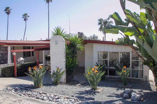a house with palm trees in front of it at Hotel Quintas Papagayo in Ensenada