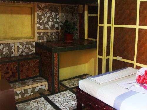 a bedroom with a bed and a table with a plant at Stefanie Grace Paradise Inn in Loboc