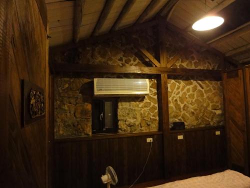 a room with a stone wall with a air conditioner at Jiufen Aromatherapy B&B in Jiufen