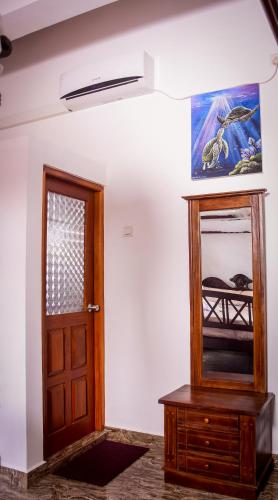 a room with a wooden door and a mirror at Channa Villa & Tours in Bentota