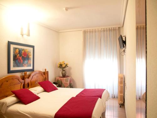 a bedroom with a large bed with red pillows at Dato 2 in Vitoria-Gasteiz
