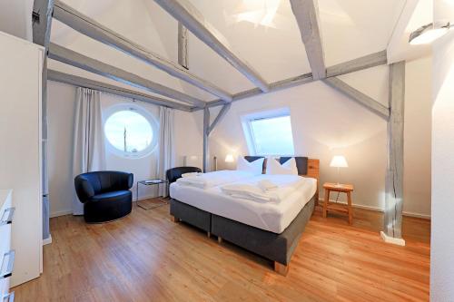 - une chambre avec un grand lit et deux chaises dans l'établissement Apartment Traveblick, à Lübeck