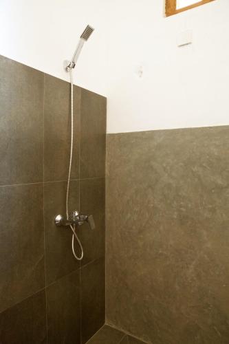 a shower with a shower head in a bathroom at Beach Inns Holiday Resort in Matara